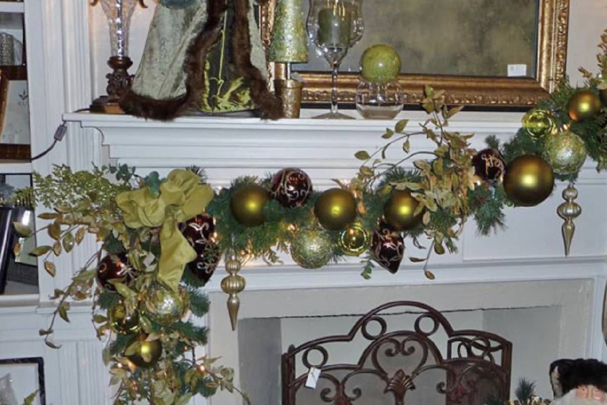 A mantle decorated for christmas with gold and green ornaments