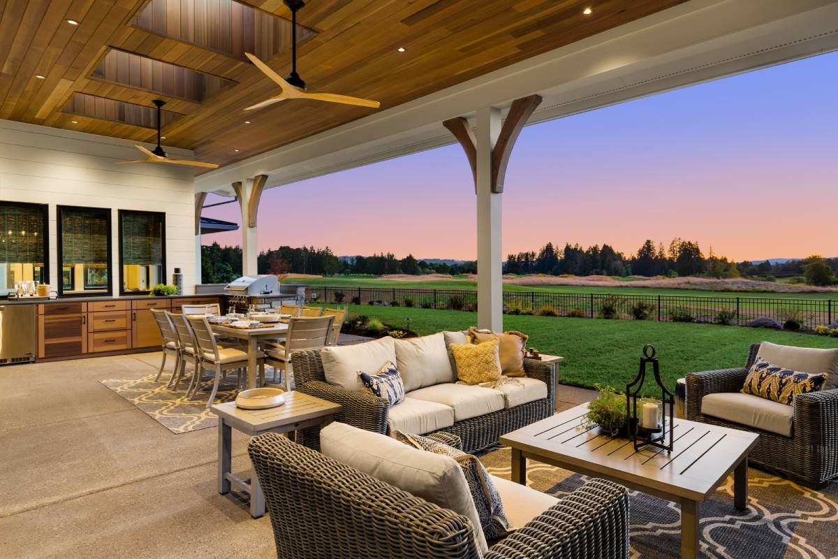 A outdoor living space with a couch , chairs , a table and a ceiling fan.