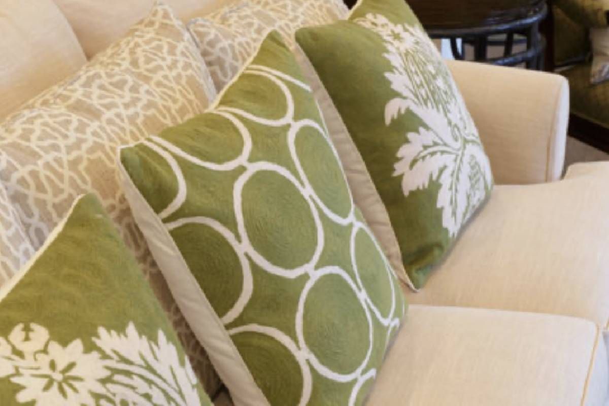 A home decorated with a white couch with green and white pillows on it