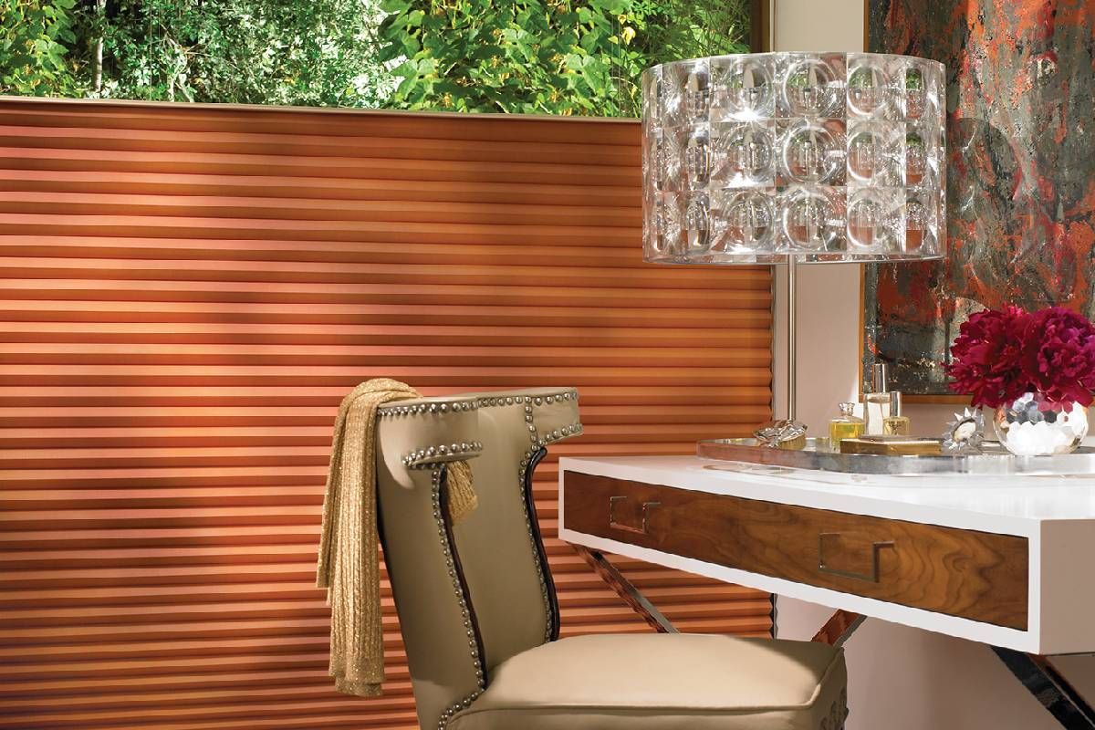 A chair is sitting in front of a desk in a room with Hunter Douglas treated windows