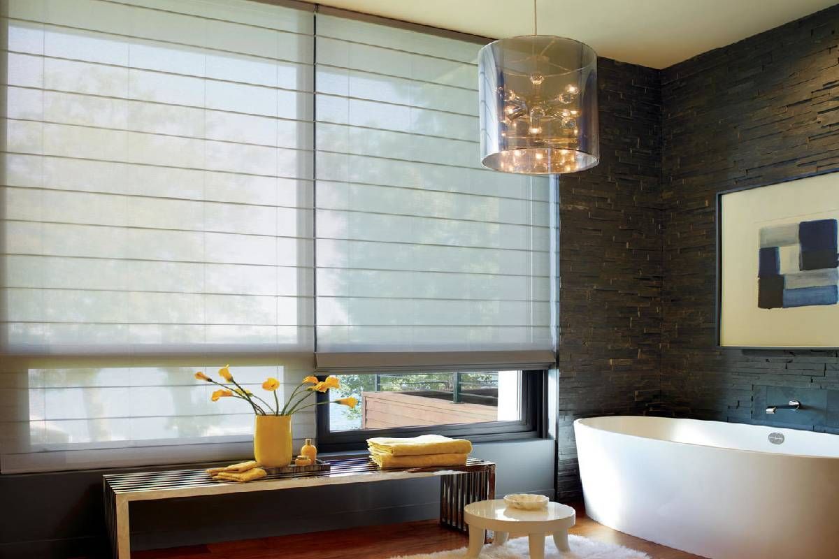 A bathroom with a tub and a window with custom roller shades