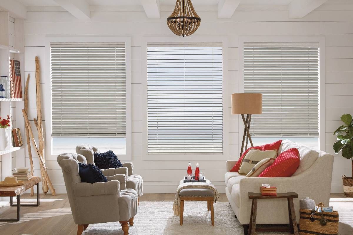 A living room with a couch , chairs , and Parkland wood blinds.