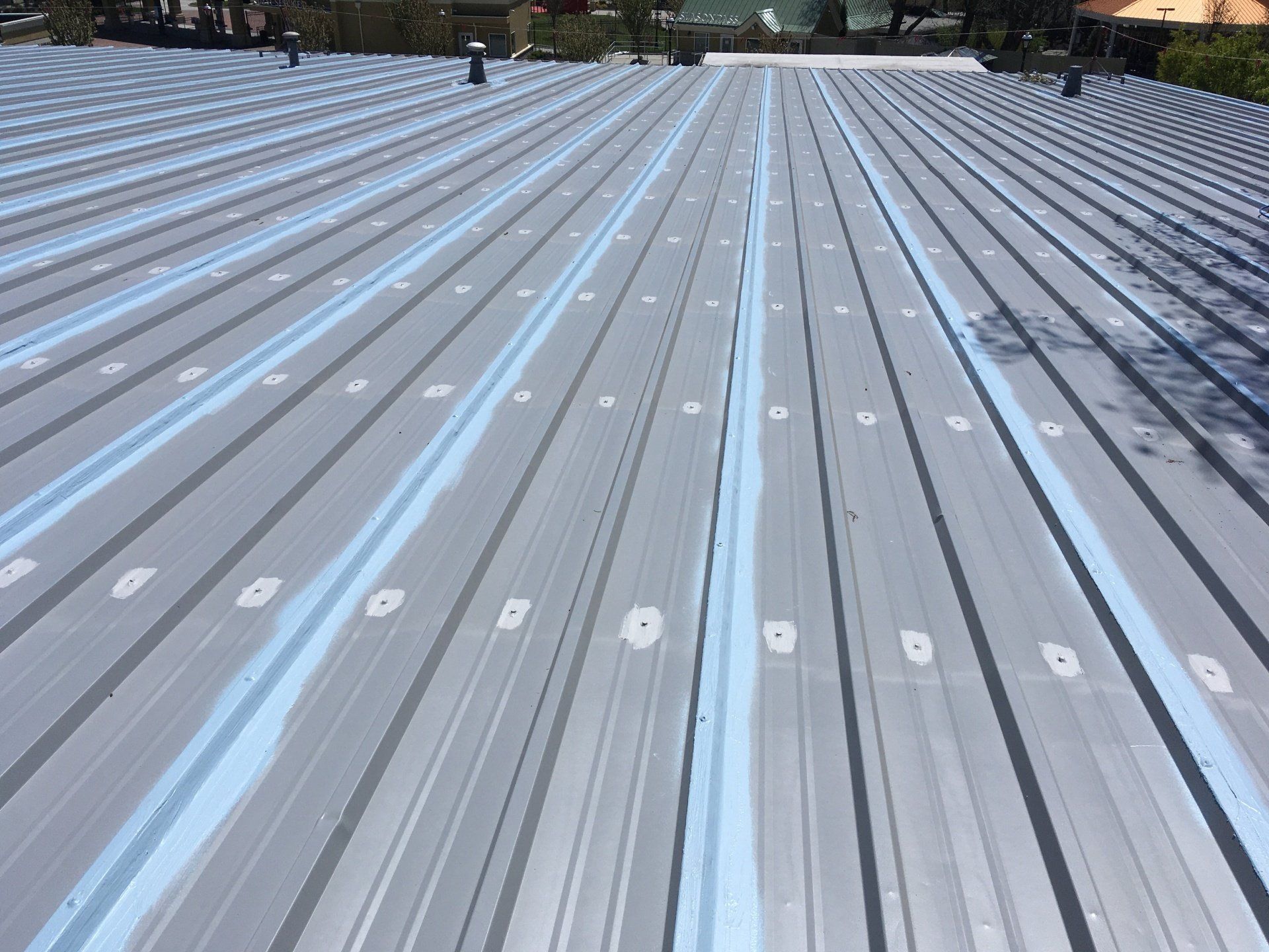 A gray metal roof with blue stripes on it
