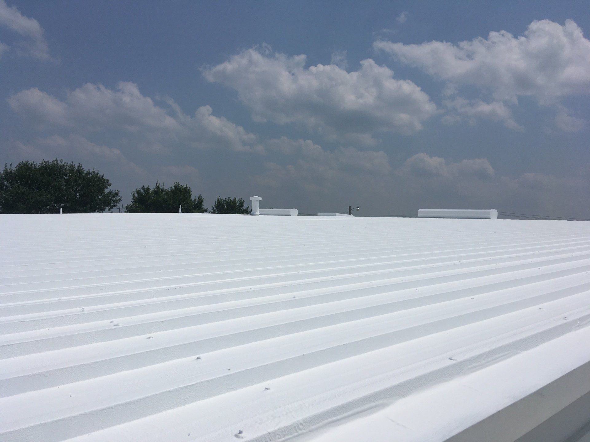 A coated white roof with a blue sky in the background.