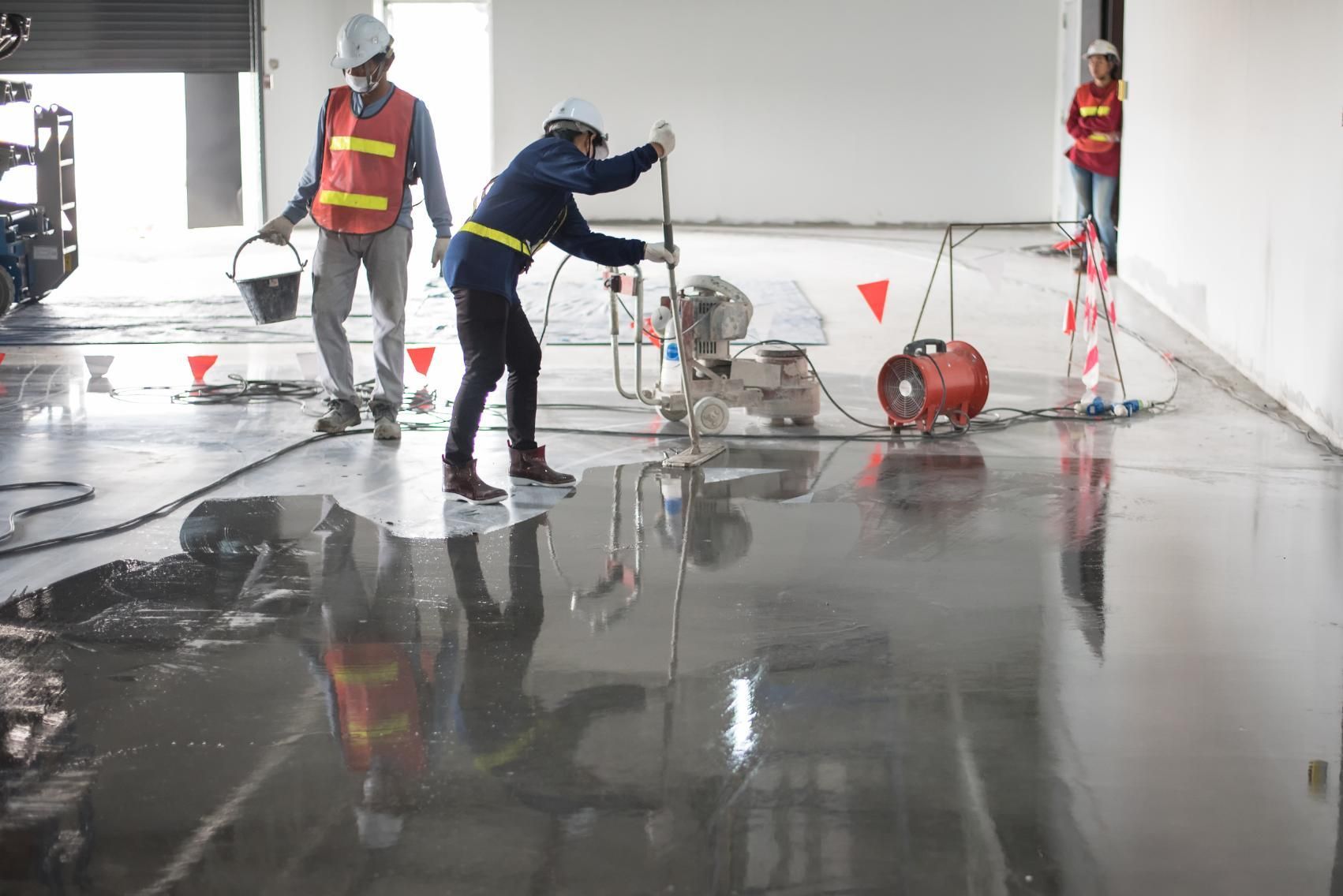 Workers Smoothing Wet Concrete Floor in a Large — Crystal Clear In Glen Innes, NSW