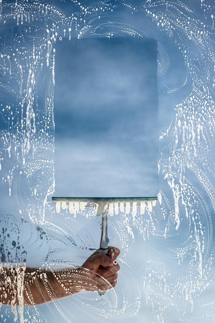 A Hand Using an Ice-covered Squeegee to Clear a Small Window — Crystal Clear In Uralla, NSW