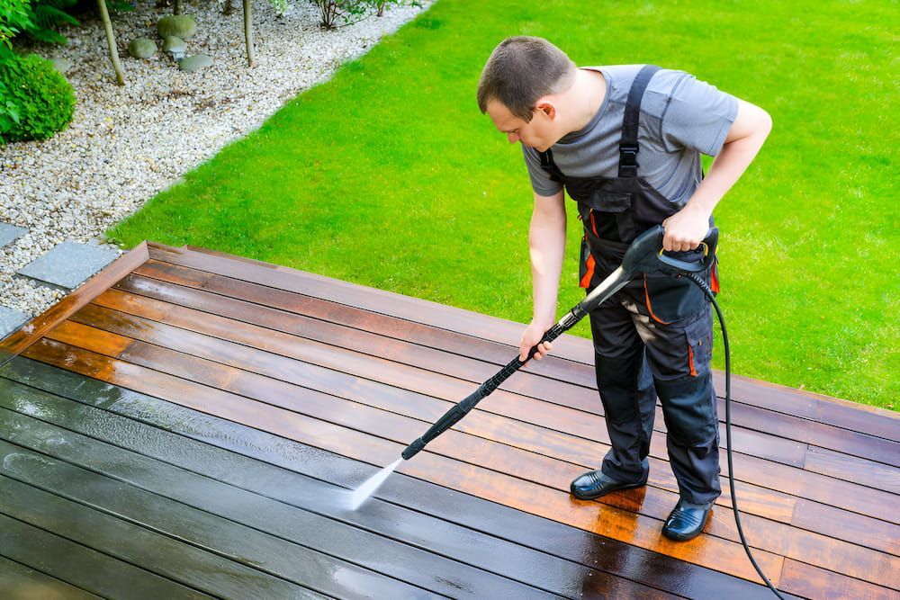 A Person Wearing Yellow Gloves Is Cleaning A Wooden Floor With A Sponge — Crystal Clear In Armidale, NSW