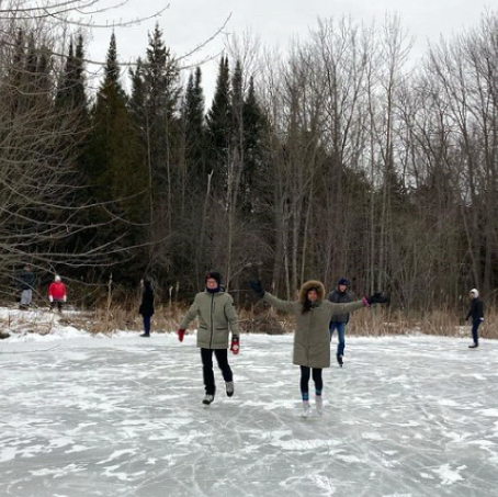 A group of people are ice skating on a frozen lake