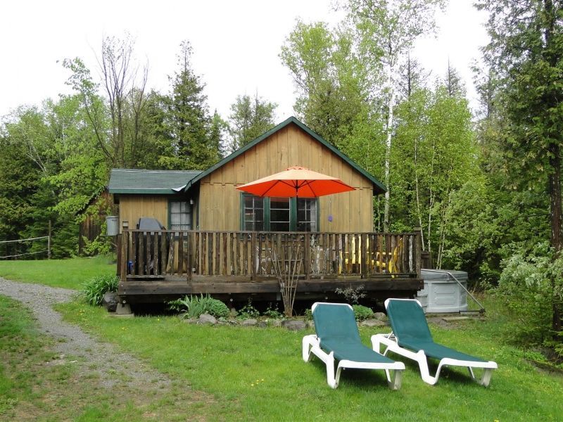 a small cabin with an orange umbrella on the deck