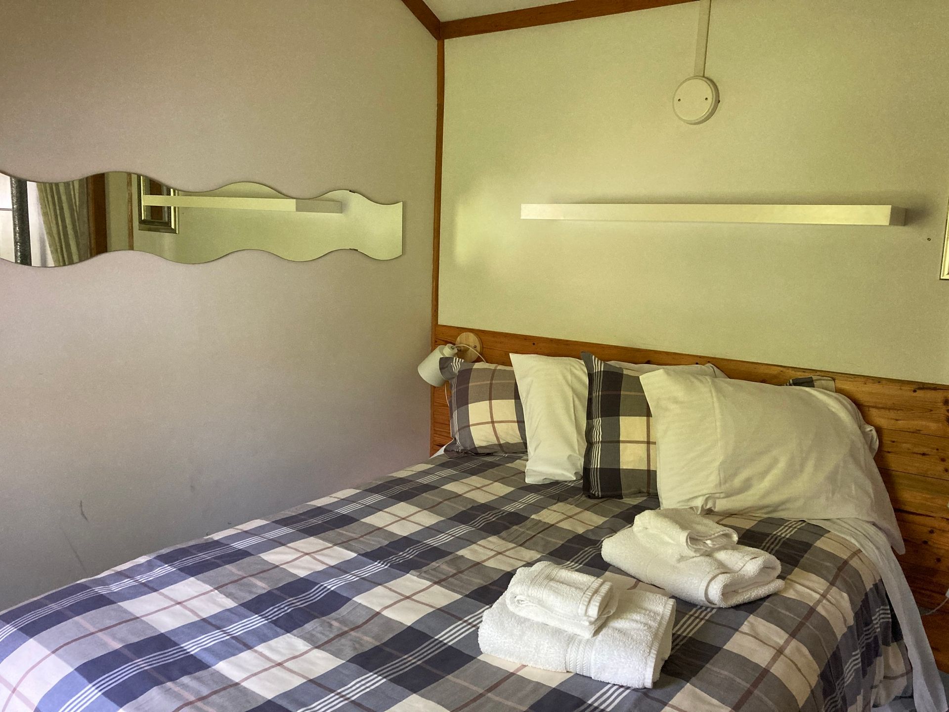 A bedroom with a bed and a mirror on the wall