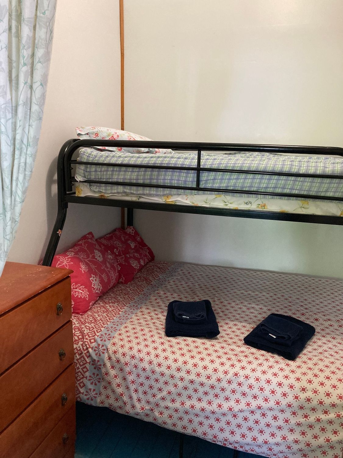 A bedroom with a bunk bed and a dresser.