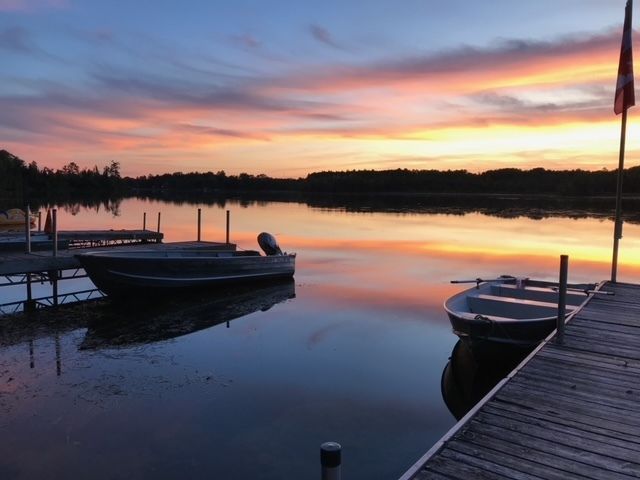 Boats are docked at a dock at sunset
