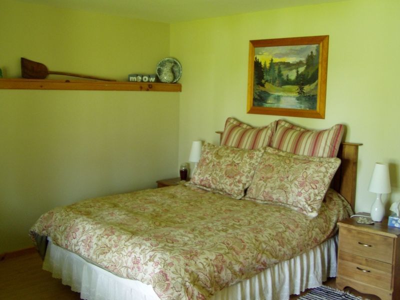 A bedroom with a bed and a painting on the wall