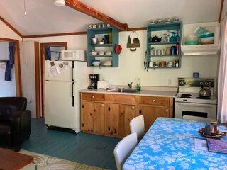 A kitchen with a table and chairs and a refrigerator.