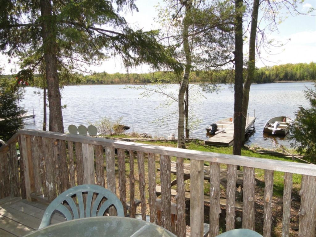 A table and chairs on a deck overlooking a lake