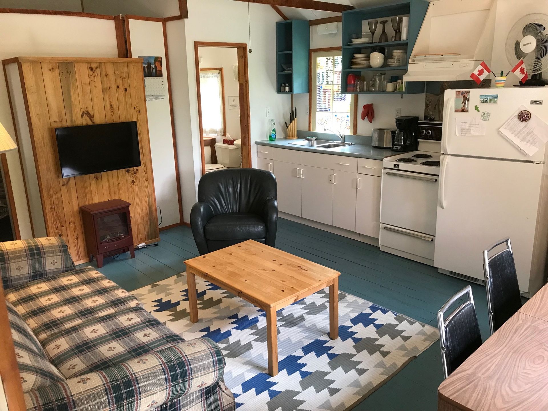 A living room with a couch , chair , table and television