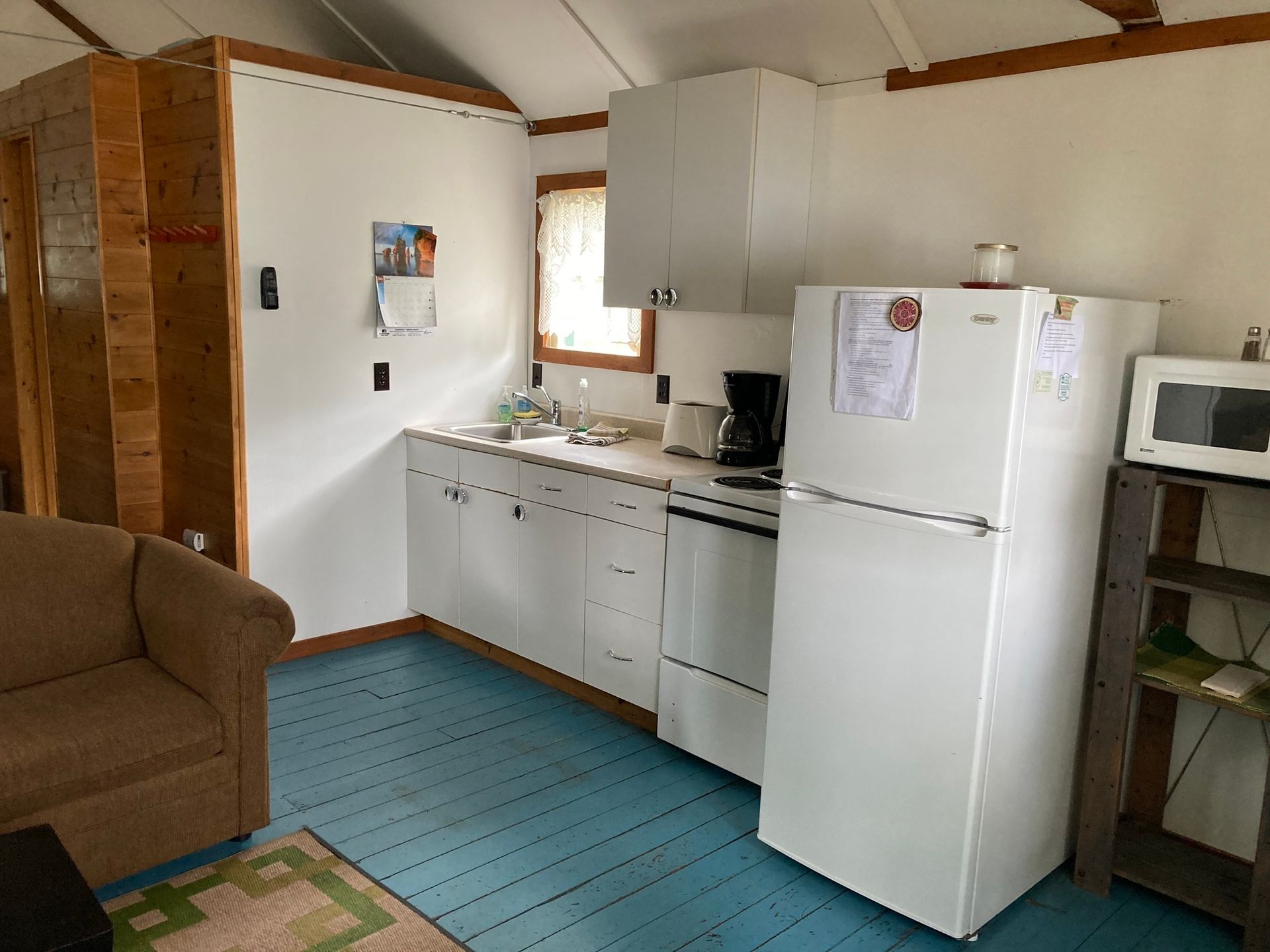 A kitchen with a white refrigerator and a microwave