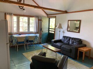 A living room with a couch , chair , table and mirror.