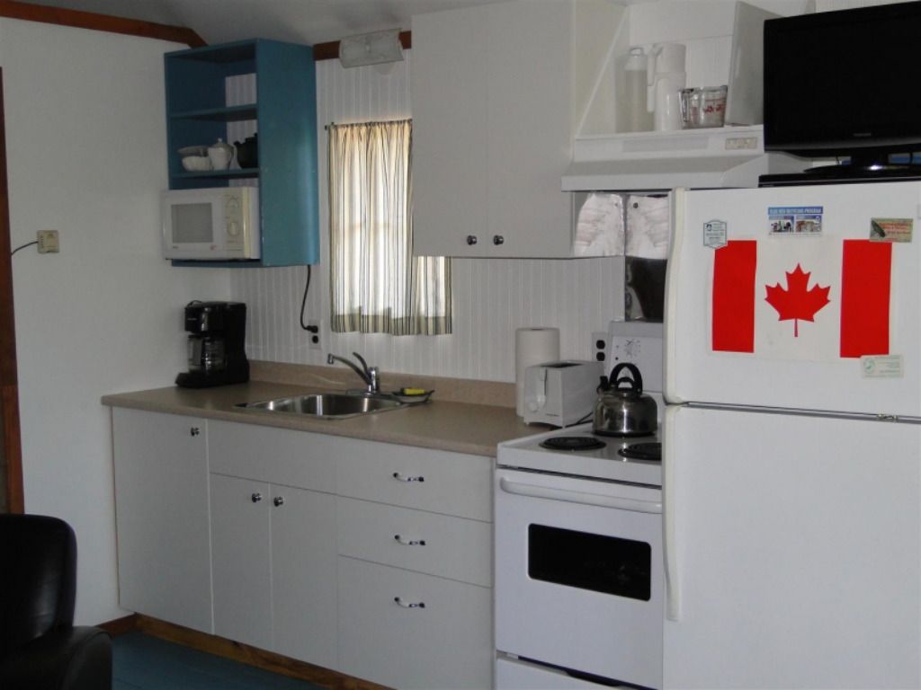 A kitchen with a canadian flag on the refrigerator