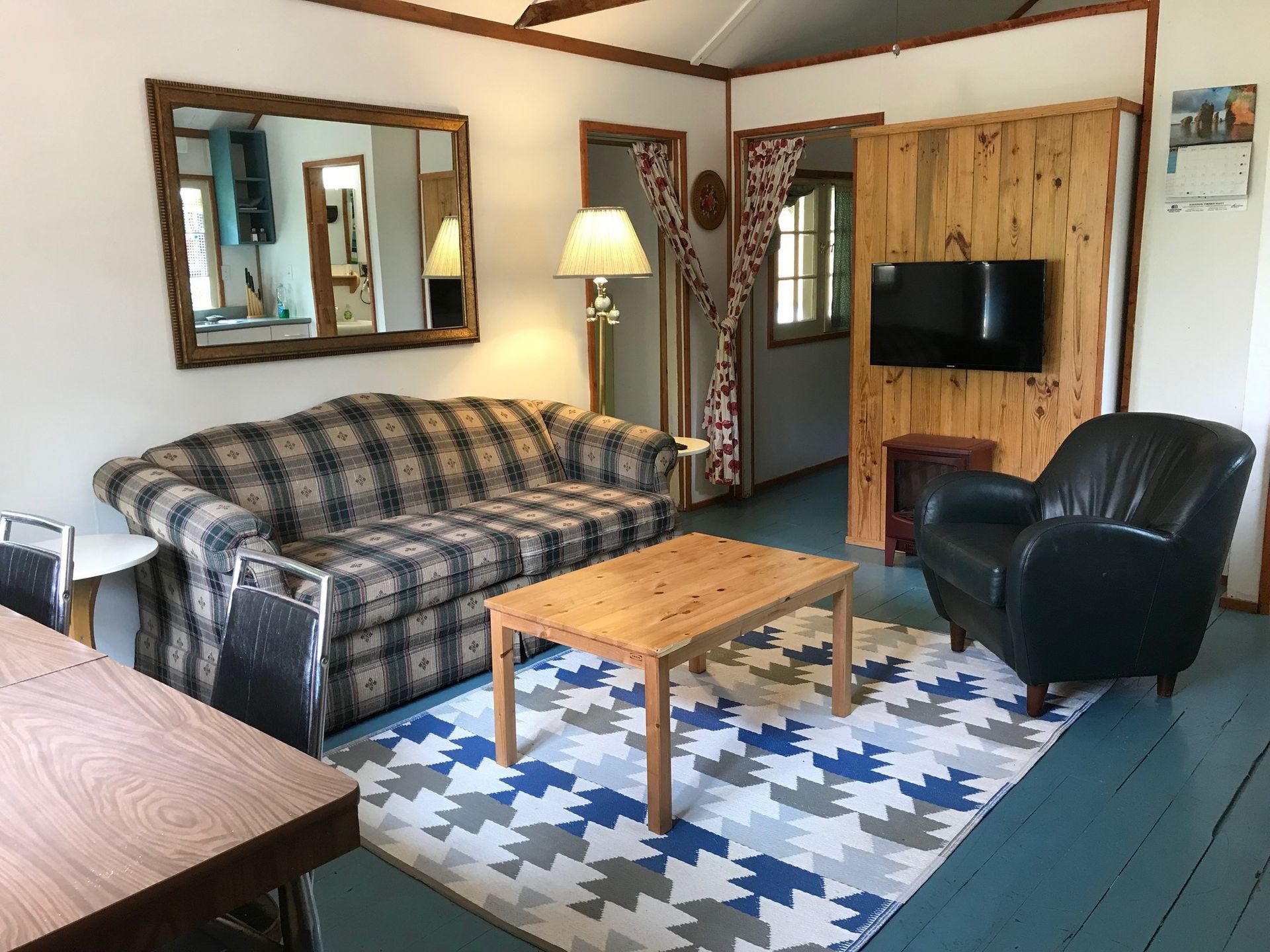 A living room with a couch , chair , table and television