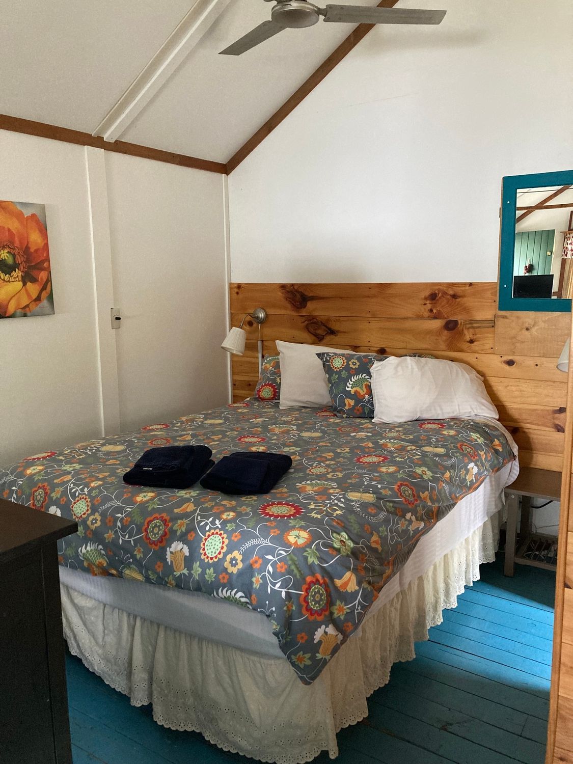 A bedroom with a bed and a ceiling fan.