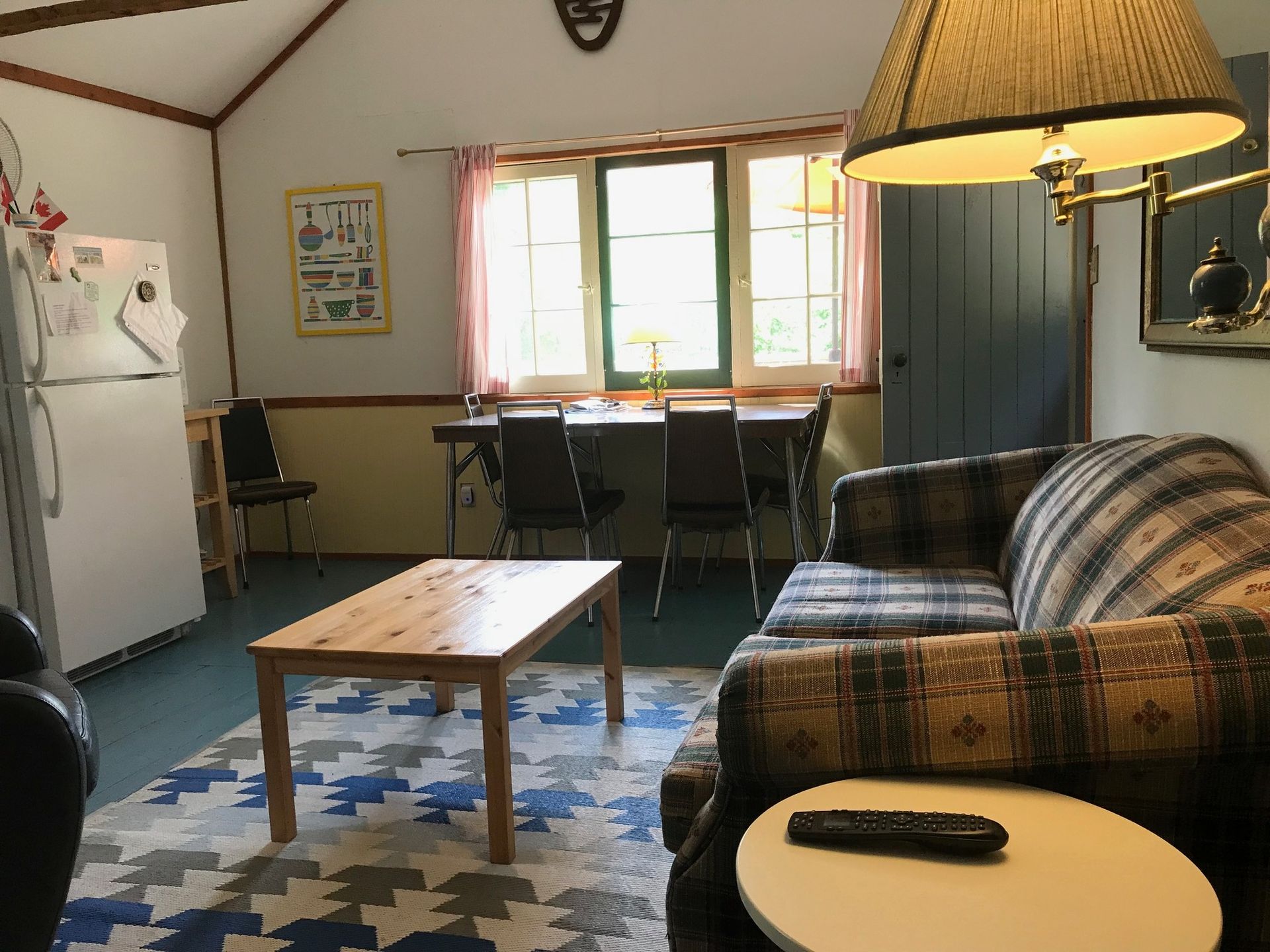 A living room with a couch , table , chairs and a lamp.