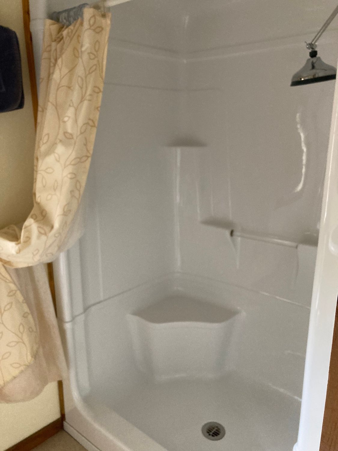 A shower stall with a shower head and a shower curtain.