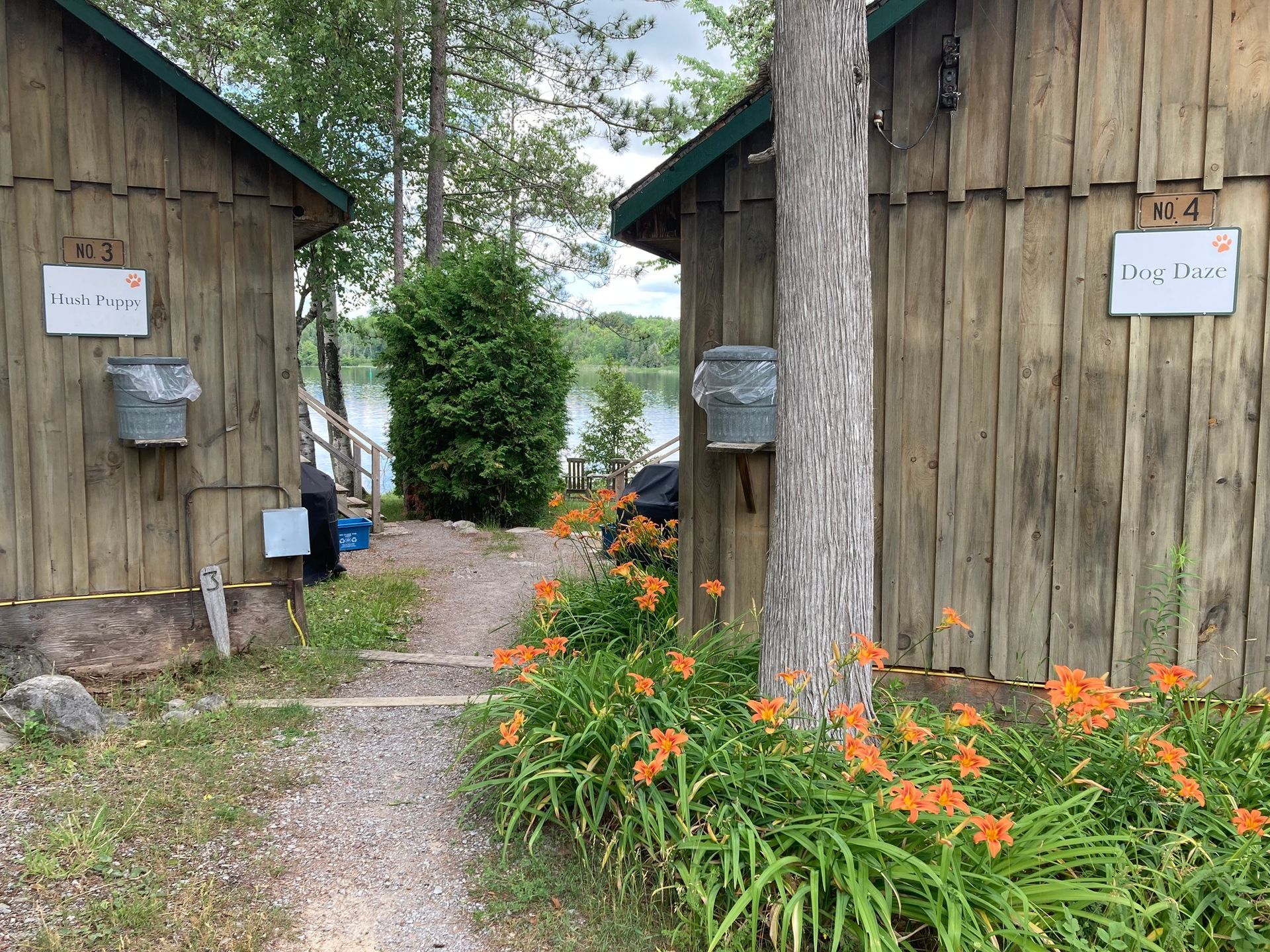 A couple of wooden buildings next to each other with flowers in front of them.