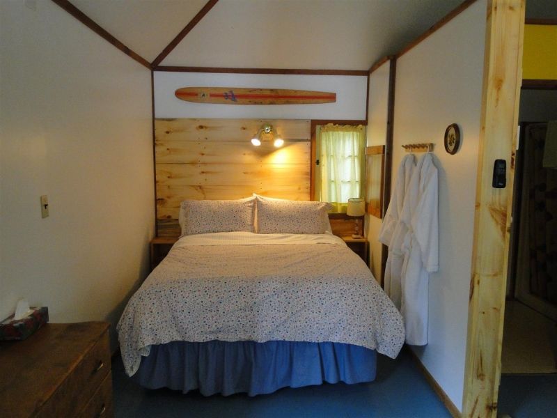 A small bedroom with a bed and a dresser