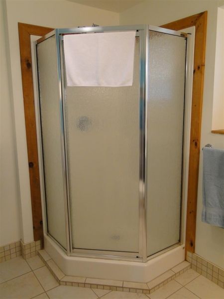 A bathroom with a shower stall and a window