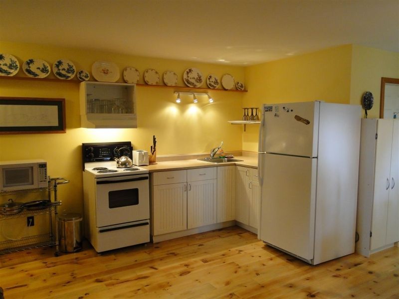 A kitchen with yellow walls and a white refrigerator