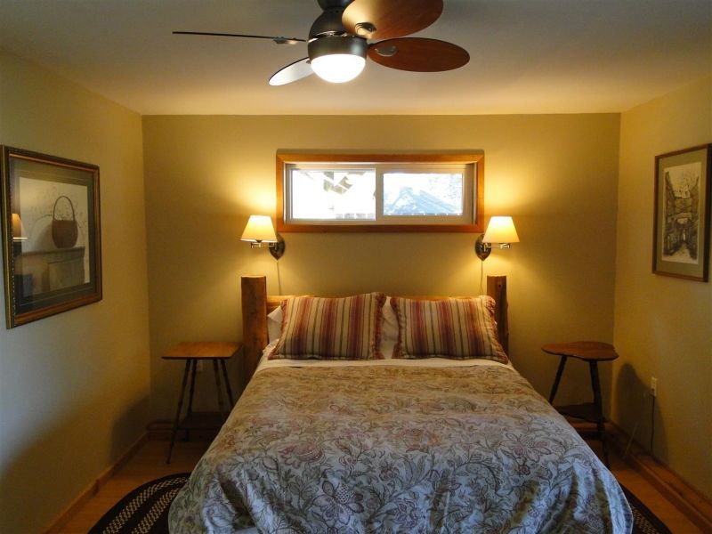 A bedroom with a bed and a ceiling fan