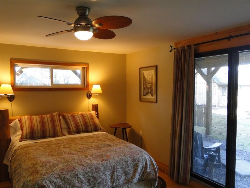 A bedroom with a bed and a ceiling fan