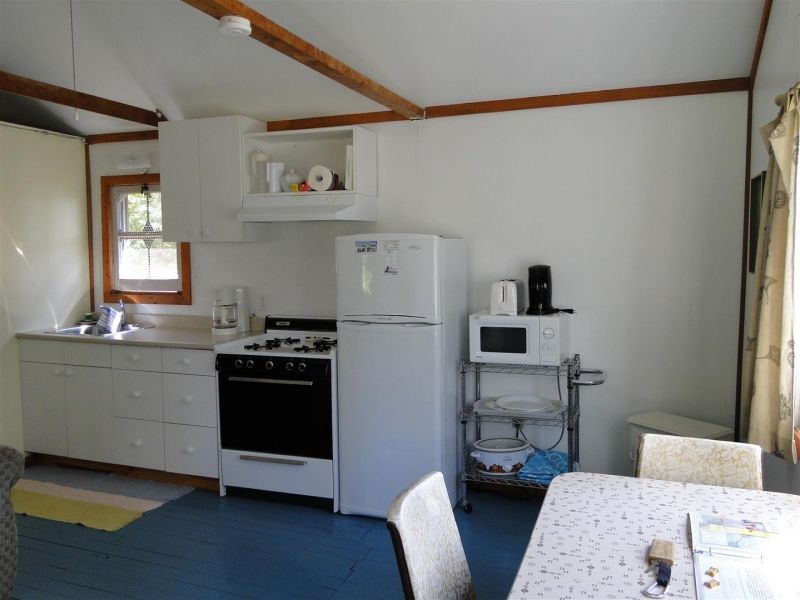 A kitchen with a stove a refrigerator and a microwave