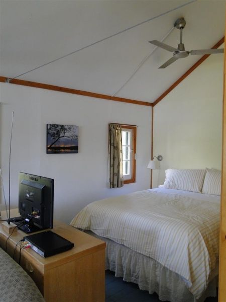 A bedroom with a large bed and a ceiling fan