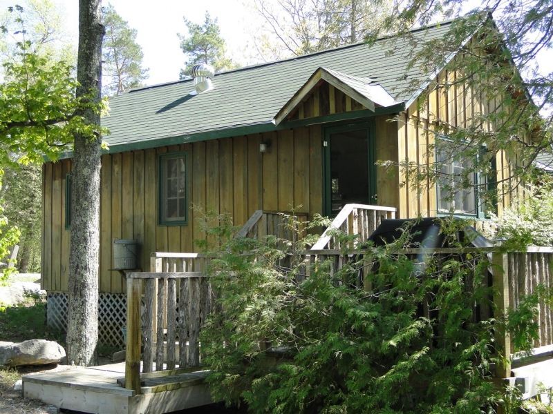 A small wooden cabin with a green roof