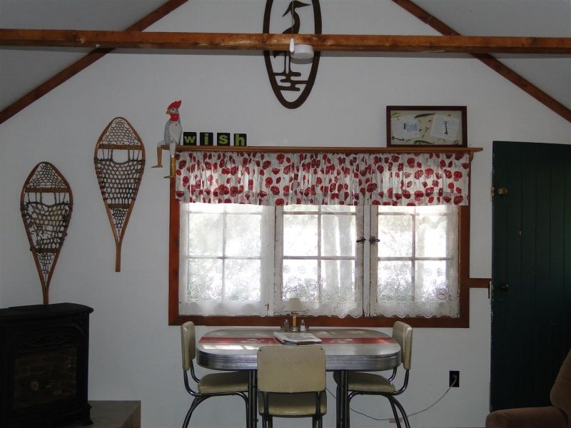 A room with a table and chairs and snowshoes on the wall