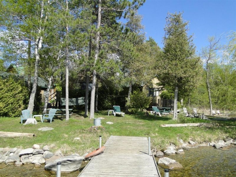 A wooden dock leading to a lake surrounded by trees