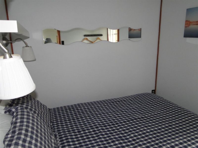 A bedroom with a bed and a mirror on the wall