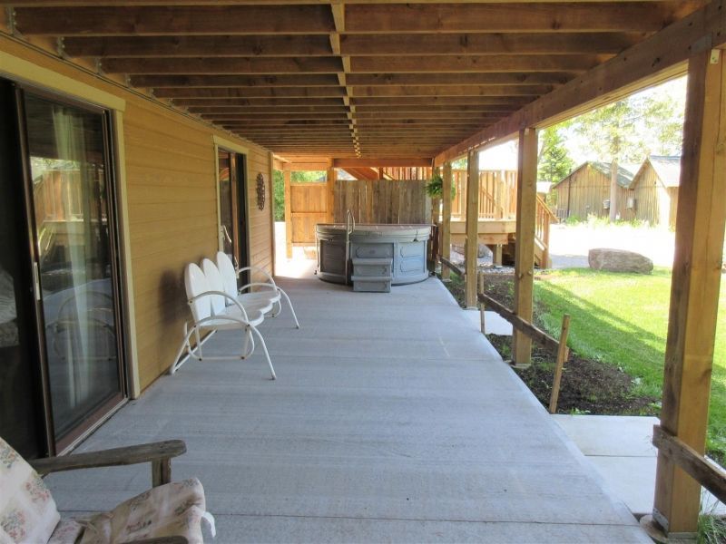 A porch with chairs and a hot tub in the background