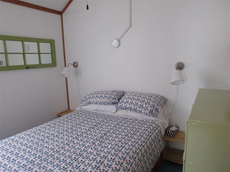 A bedroom with a bed and a green window