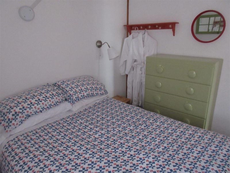 A bedroom with a bed and a green dresser