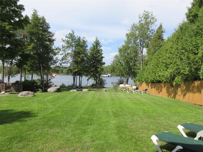 A lush green lawn with a lake in the background