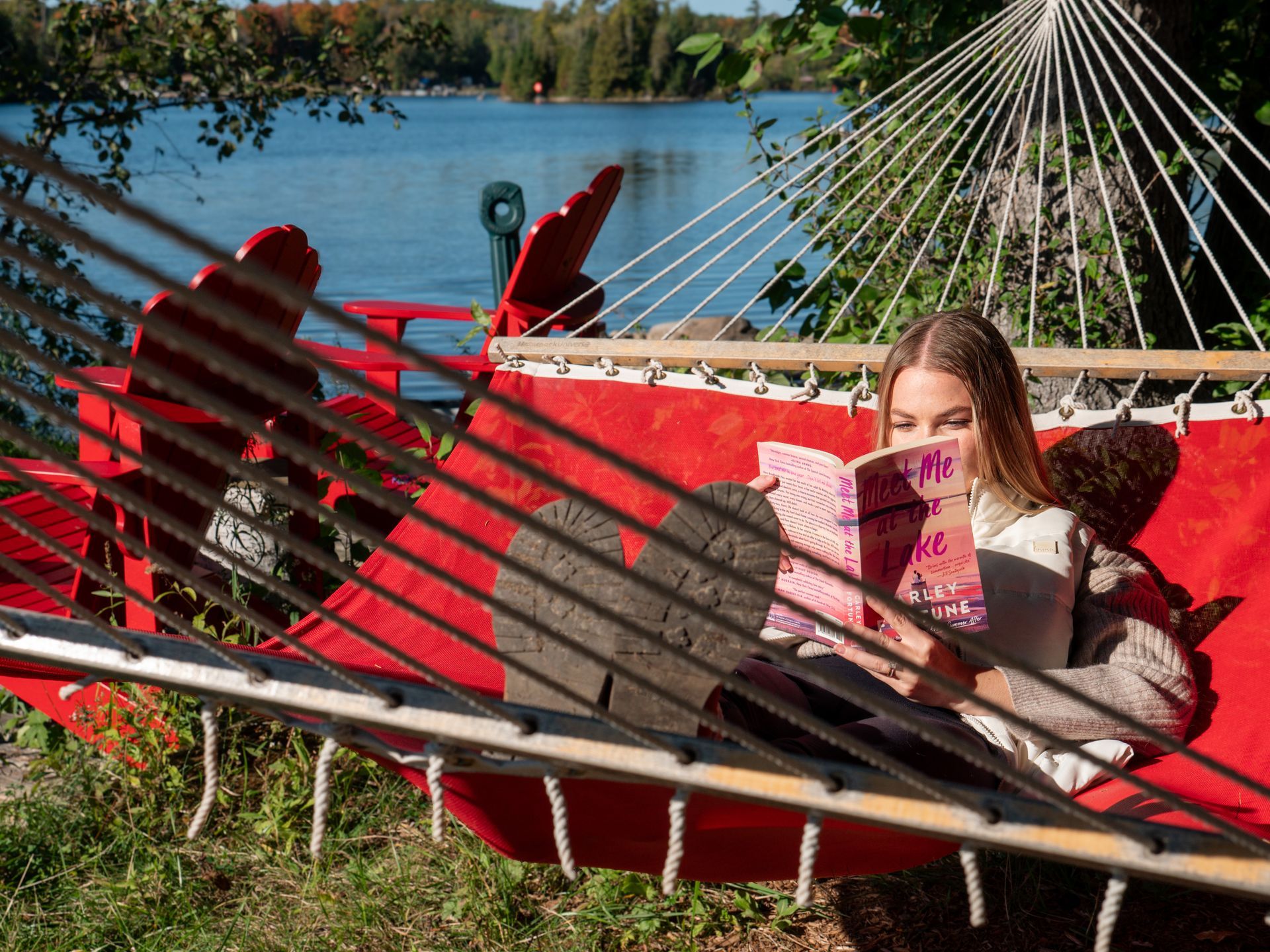 A sunset over a lake with snow on the shore