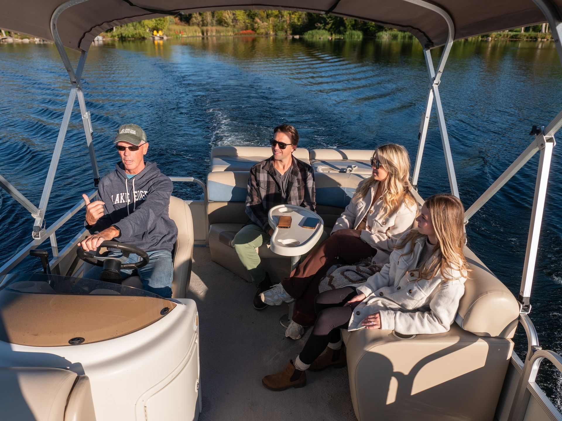 People on a pontoon boat enjoying a sunny day on the water.