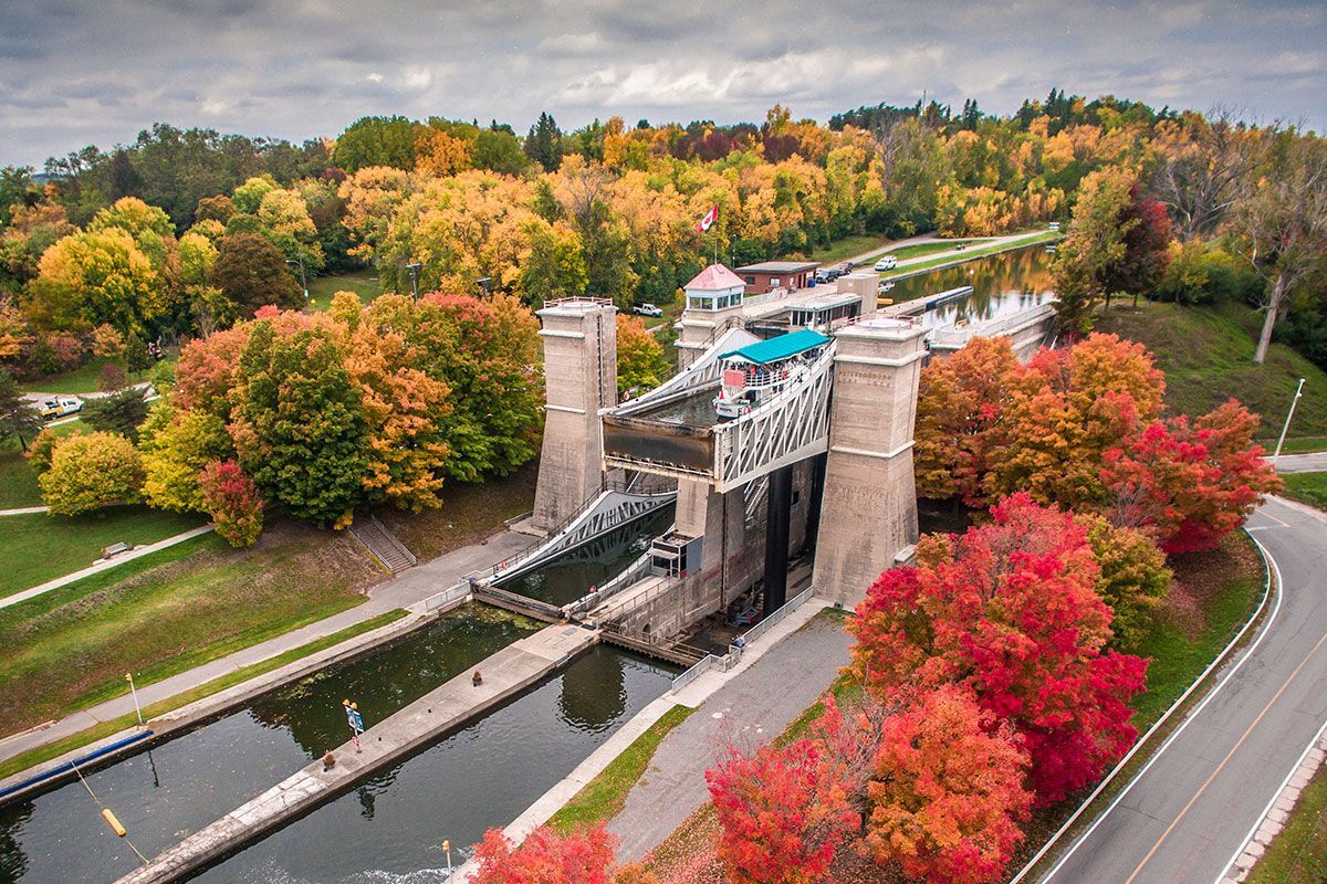 An aerial view of a bridge over a river with trees in the background.