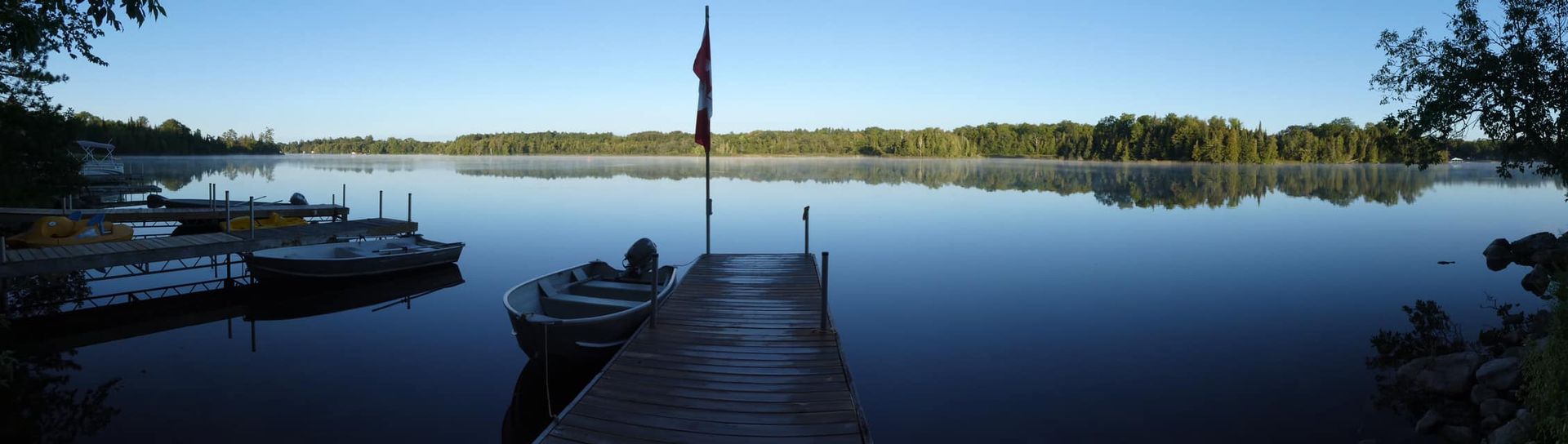 A boat is docked at a dock on a lake