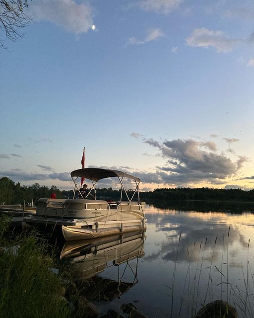 A boat is docked at a dock on a lake