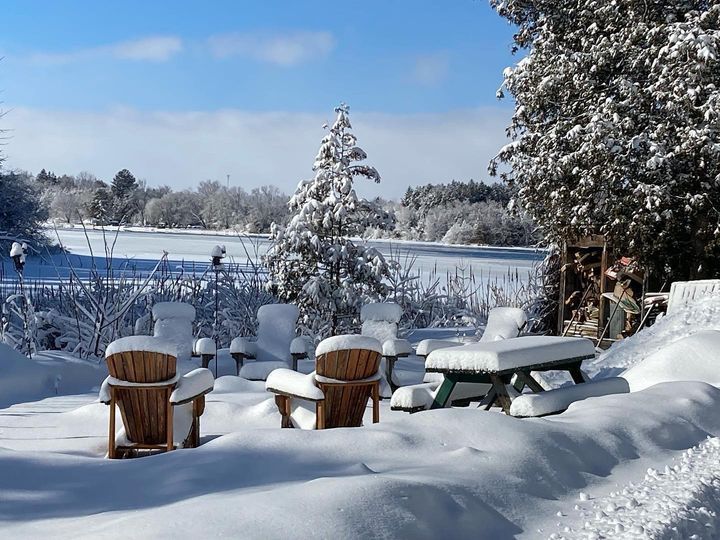 Chairs and a picnic table are covered in snow