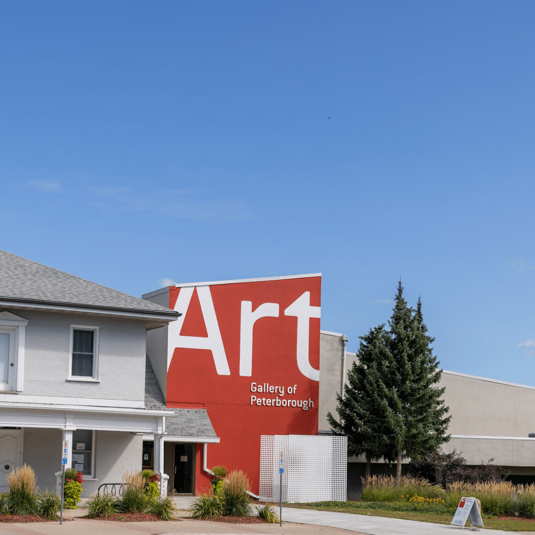 A white house with a large red sign that says art